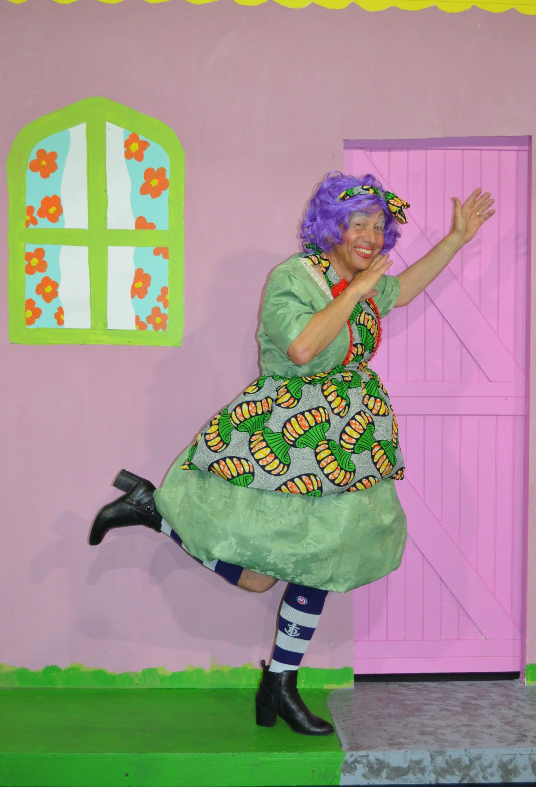 Chris Juckes as the Dame, in a very fetching green dress and purple wig striking a pose on the set of Jack and the Beanstalk