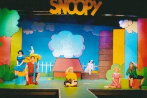 The cast of Snoopy on stage mid song