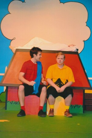 Linus and Charlie Brown having a chat on stage in front of Snoopys kennel