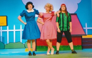 Lucy, Sally and Peppermint Patty standing on stage