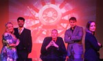 Group shot of all cast on stage in character.
